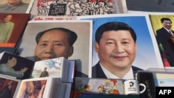 2018年2月26日，北京一个市场陈列的中国国家主席习近平像和前共产党领袖毛泽东像。