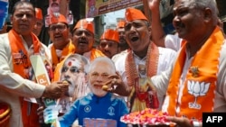 印度总理纳伦德拉·莫迪(Narendra Modi)的支持者祝贺他在印度大选初步计票中明显胜出。（法新社） 