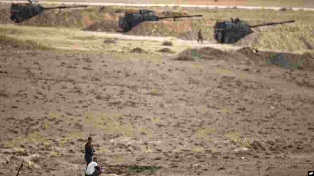 Người Kurd phía bên kia biên giới theo dõi cuộc chiến ở thị trấn Kobani từ một đỉnh đồi ở ngoại ô Suruc, Thổ Nhĩ Kỳ.