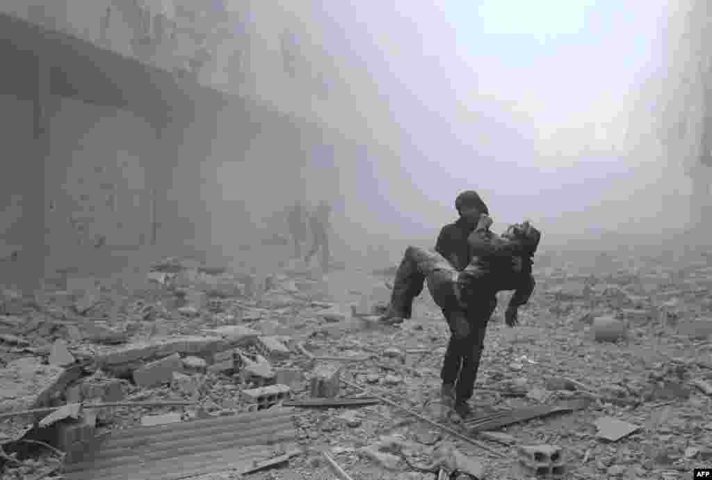 A wounded man is carried following an airstrike on the rebel-held besieged town of Arbin, in the eastern Ghouta region on the outskirts of the capital Damascus, Syria, Jan. 2, 2018.