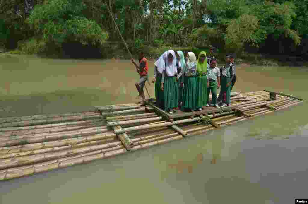 Students use a bamboo raft to cross the Ciputrahaji River in Sukasari Village, Ciamis Regency, West Java, Indonesia in this photo taken by Antara Foto, March 7, 2018.