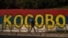 Пішохід проходить повз стінопис, пофарбований у кольори сербського прапора, з написом «Косово» в Белграді, 1 жовтня 2023 року. Фото AFP