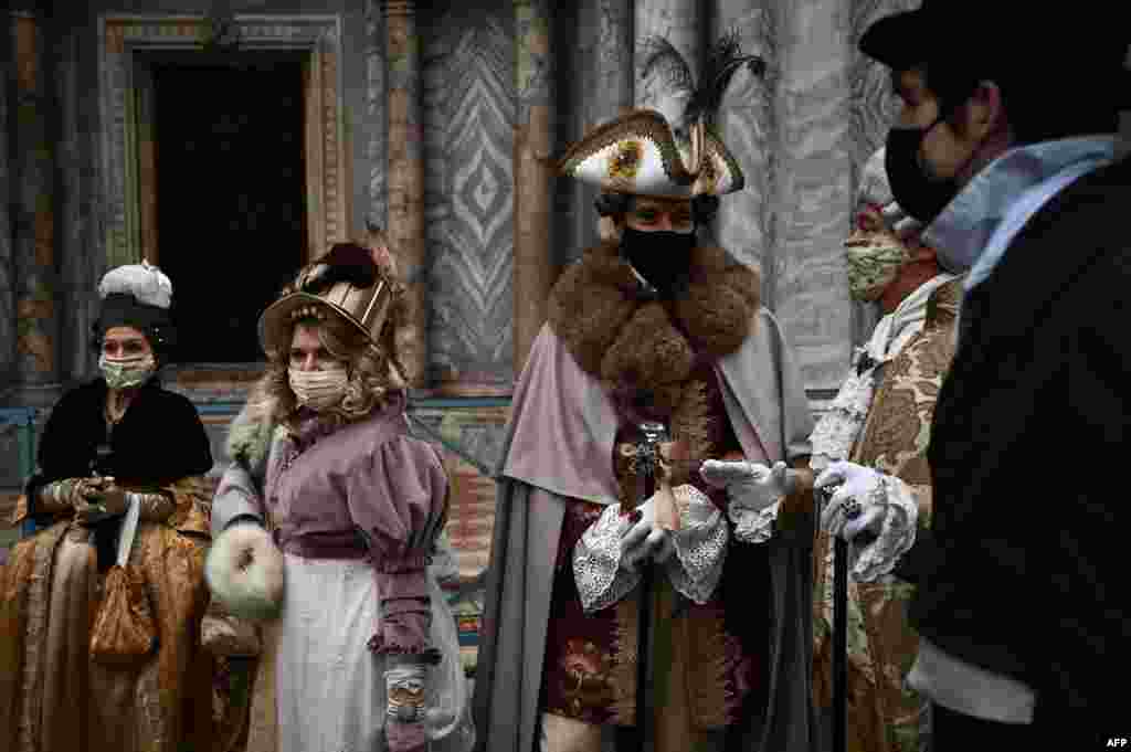 People wearing carnival costumes parade across St. Mark's Square in Venice, Italy, Feb. 6, 2021, despite the carnival is cancelled due to the Covid-19 pandemic.