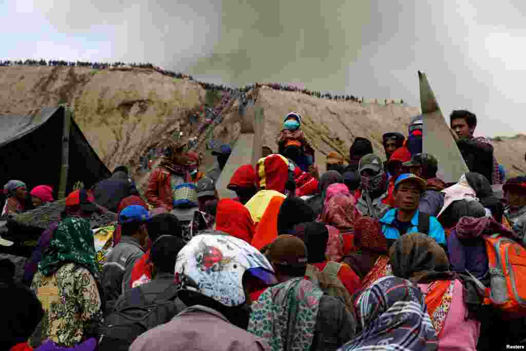 Núi Bromo phun tro trong lúc dân làng Hindu và du khách tập trung trước buổi lễ Kasada với tập tục ném đồ cúng tế vào miệng núi lửa. Hình chụp tại Probolinggo, Indonesia. 