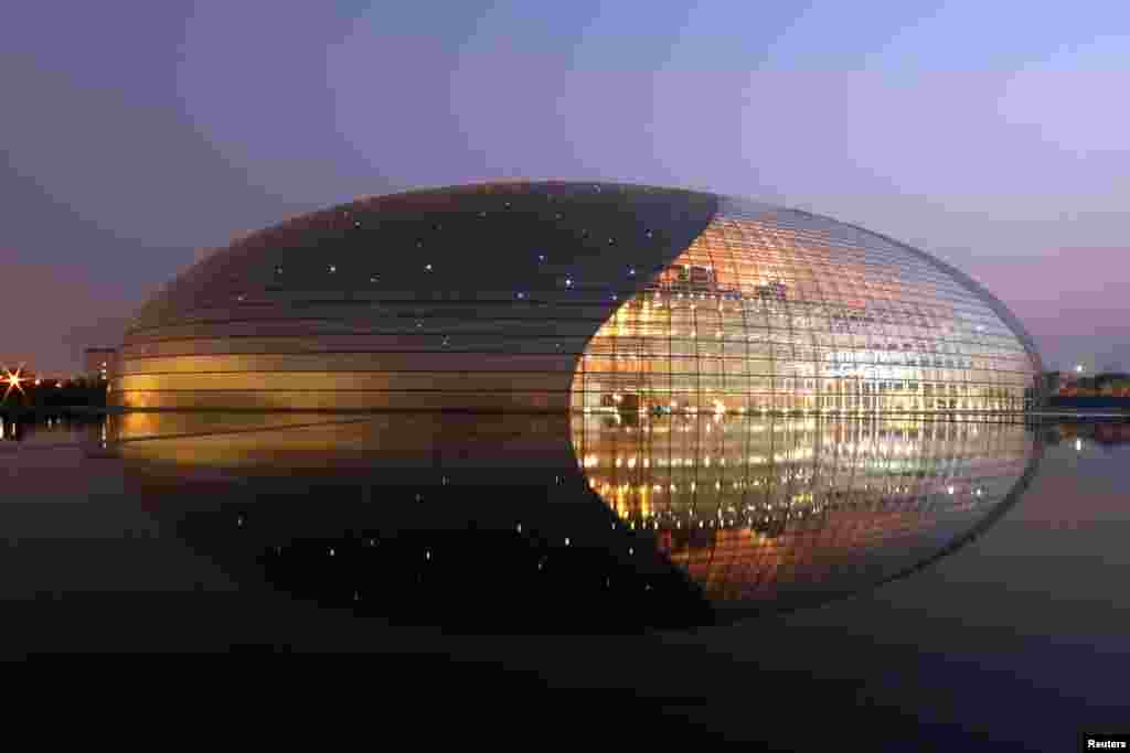 北京国家大剧院夜景 (2007年9月24日)。由法国建筑师保罗·安德鲁设计的这座泪滴形剧院由玻璃和钛制成,该剧院的开场演出剧目是芭蕾舞剧“红色娘子军”。