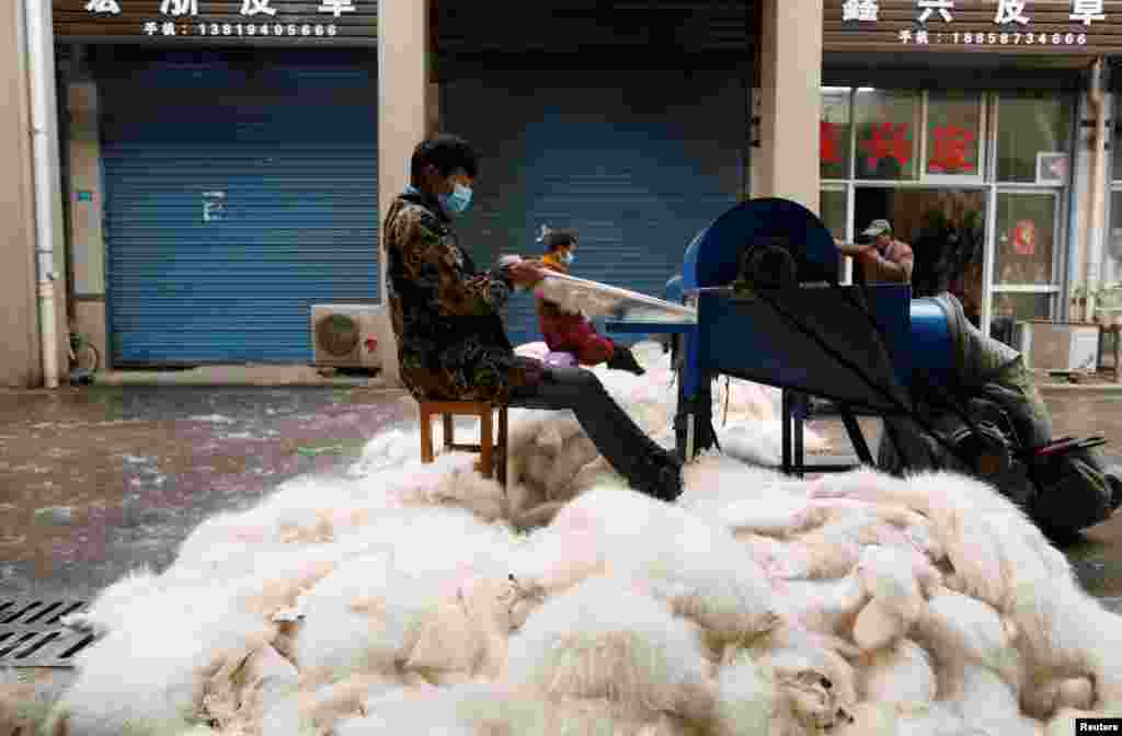 Workers process fox fur with machinery at a fur market in Chongfu, Zhejiang province, China.