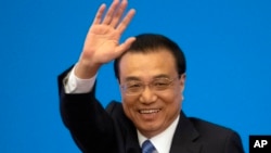 资料图片：2019年3月15日，在北京人民大会堂，全国人民代表大会闭幕后，时任国务院总理李克强在记者会上挥手致意。(美联社)