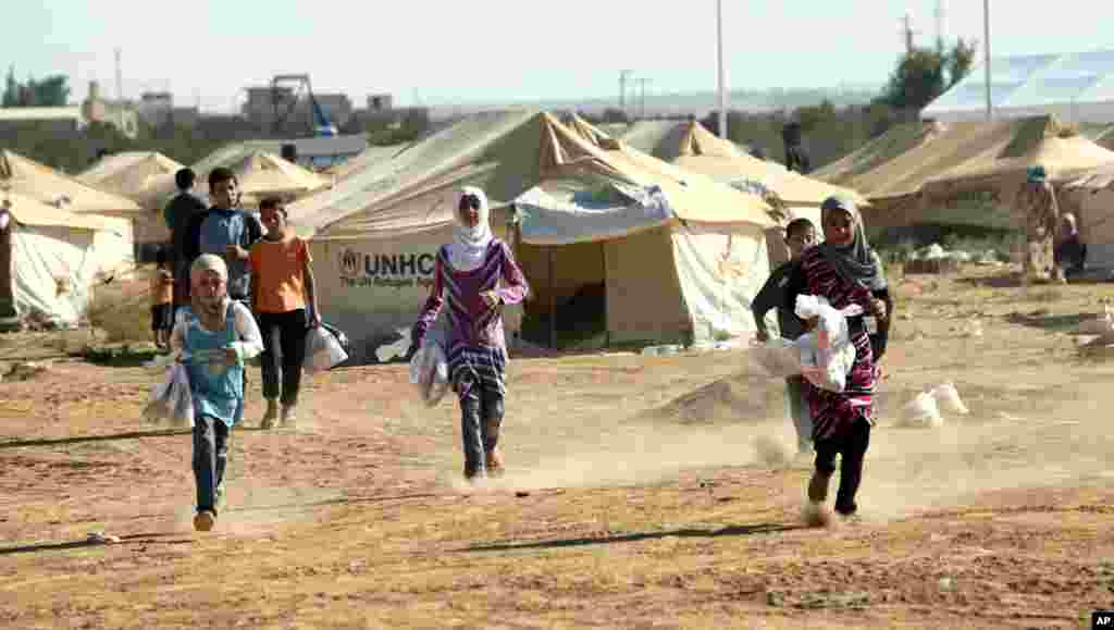 Trẻ em Syria trong trại tị nạn Zaatari, ở Mafraq, Jordan, cầm các món quà truyền thống gồm đồ chơi, quần áo do các nhà hảo tâm và các tổ chức quốc tế tặng