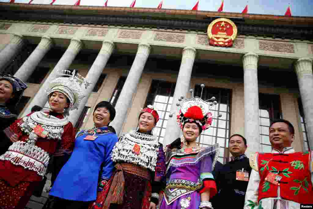 2018年3月5日在北京举行的中国人大开幕会前,穿戴少数民族服饰的代表站在人民大会堂外。