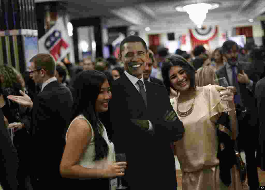 Khách tham dự chụp ảnh cùng chân dung Tổng thống Barack Obama trong buổi họp mặt đêm bầu cử 2012 tại khách sạn Intercontinental ở Madrid, Tây Ban Nha.