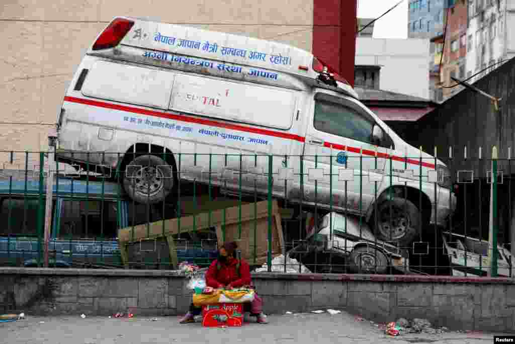 A street vendor sits out a hospital compound with an abandoned ambulance as the major second coronavirus wave surges in Kathmandu, Nepal. 