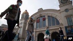 2020年4月7日武汉恢复交通前夕，带着行李的旅客走过汉口火车站。