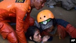 救援人员从一所被地震和海啸摧毁的房屋中解救一名15岁的印尼女孩。 （2018年9月30日）