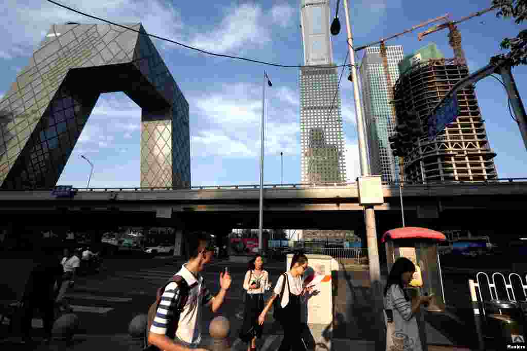 人们走近北京中央商务区的中央电视台（CCTV）大楼附近（2018年8月16日）。 8月22日，中国教育部通知全国各地的学校，要学生和家长在9月1日晚上8点一起观看教育部和中央广播电视总台联合制作的节目《开学第一课》。 一些地方学校当局还要求学生家长&ldquo;发一张孩子与家人一起观看节目的照片分享到班级群&rdquo; 。但观众先看到的是将近15分钟的连续广告， 有推广培训机构的，有宣传学习APP 的。有人说这是广告第一课。有人写道：&ldquo; 是该骂！第一不守时，第二强制观看，第三一边喊着减负，一边大力做培训广告？我想说这是来搞笑的吗？ &rdquo;