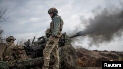 Українські 1-го окремого механізованого батальйону "Вовки Да Вінчі", названого іменем загиблого героя України Дмитра Коцюбайла, стріляють з гаубиці M119 у Бахмуті, 10 березня 2023. REUTERS/Oleksandr Ratushniak