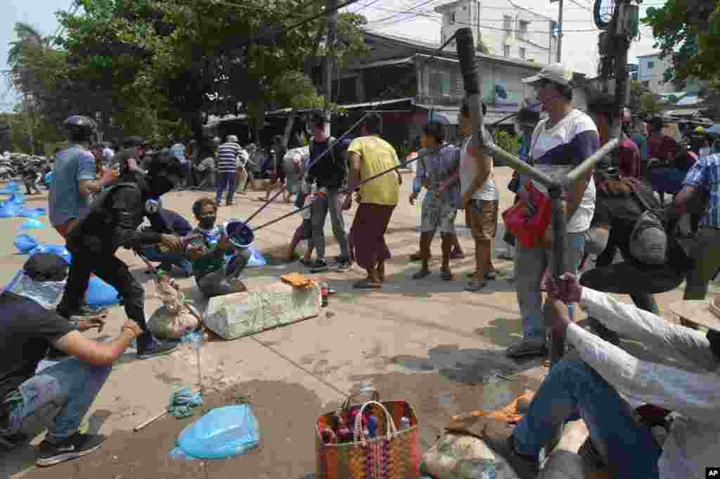 Anti-coup protesters use oversized slingshot to confront police in Yangon, Myanmar. Protesters returned to the streets to press their demands for a return to democracy, just a day after security forces killed more than 100 people in the bloodiest day since last month's military coup.