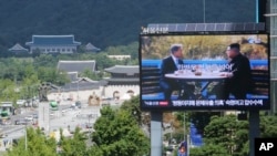 电视屏幕上显示韩国总统文在寅和朝鲜领导人金正恩的照片，标题为： 朝鲜半岛和平。