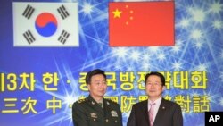 韩国国防部次官白承周（右）与中国人民解放军副总参谋长王冠中在首尔参加第三次韩中国防战略对话。（2013年11月28日）