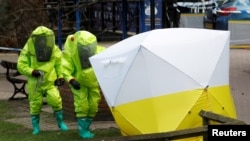Експерти накривають спеціальним шатром лавочку, на якій знайдено Скрипалів