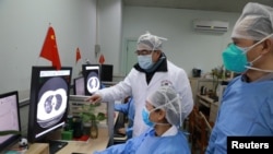 2020年2月2日，湖北省武汉市新冠病毒爆发后，医务人员在武汉大学中南医院检查一名患者的CT扫描图像。