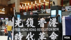 资料照：在台北车站参与支持香港行动的民众高举“光复香港时代革命”旗帜。 （2020年5月23日）