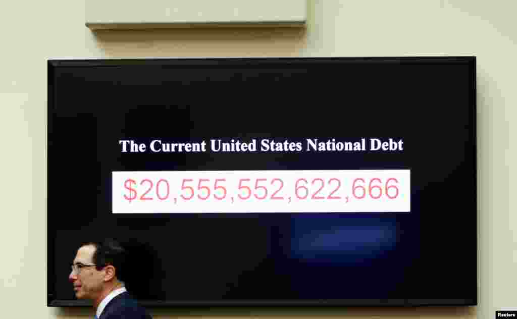 Treasury Secretary Steven Mnuchin walks past a display of the U.S. national debt as he testifies to the House Financial Services Committee on "The Annual Report of the Financial Stability Oversight Council," on Capitol Hill in Washington.